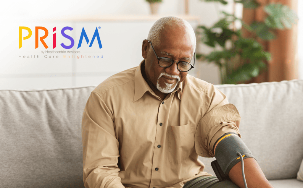 Older man sitting on couch taking blood pressure