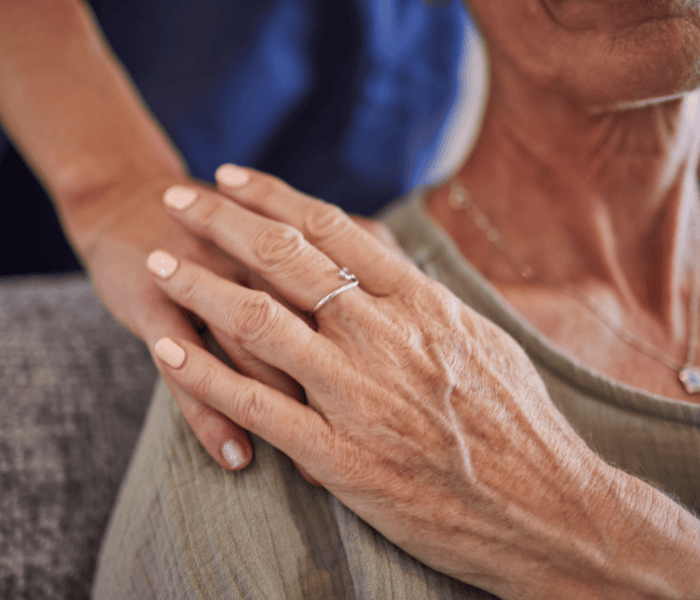 Nurse holding elderly womans hand