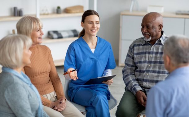 Nurse sitting and talking to a group of seniors.