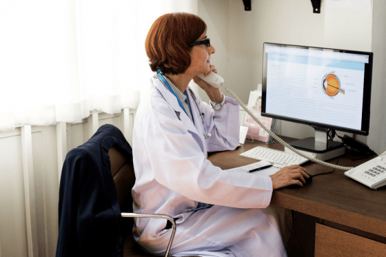 A healthcare provider sitting at her desk and talking on the phone.
